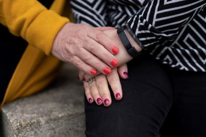 Close up of two people with painted nails holding hands