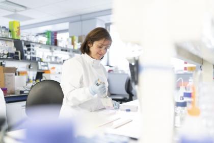 A female ovarian cancer researcher smiling while working in a lab