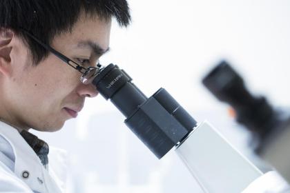 An ovarian cancer researching looking into a microscope