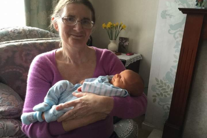 Gillian smiling holding her baby great nephew