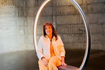 Reeta smiling sat in a hoop chair