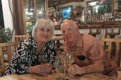 Sue and her husband having a drink in a bar, both smiling and happy