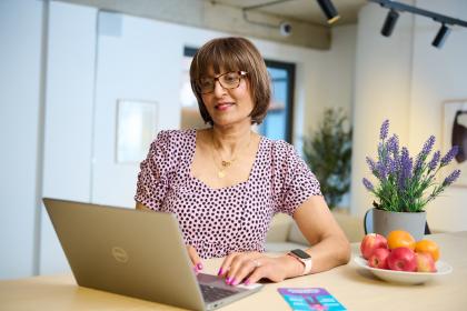 A woman sitting at the table on her laptop