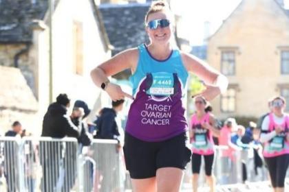 A female supporter smiling and running at Oxford Half Marathon, 2023