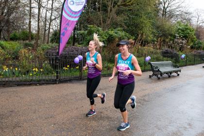Two females running and smiling at Run 11, 2023
