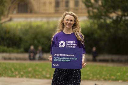 Charlotte standing outisde Westminster Parliament in a purple Target Ovarian Cancer tshirt