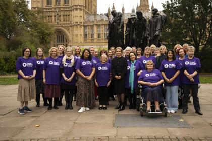 A group of Target Ovarian Cancer campaigners standing outside parliament wearing purple TOC tshirts with new CEO Catherine standing in the middle