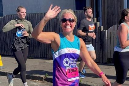 Female supporter smiling and running at Edinburgh Half Marathon 2025