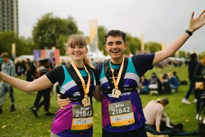 Male and Female supporter smiling and waving at Royal Parks Half Marathon 2024
