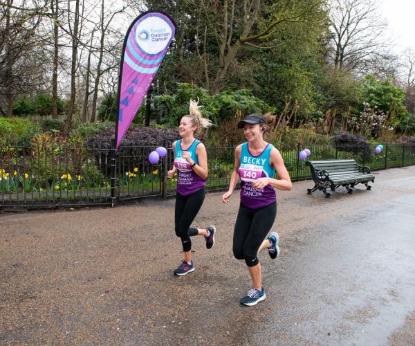Two females running and smiling at Run 11, 2023