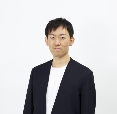 A headshot of Jun Ishihara wearing a black blazer and white tshirt looking straight at the camera