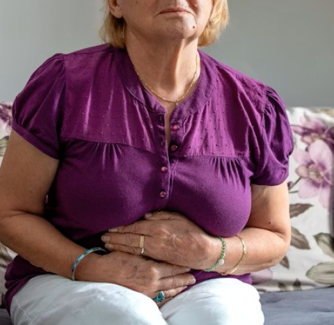 A woman holding her hands to her tummy area