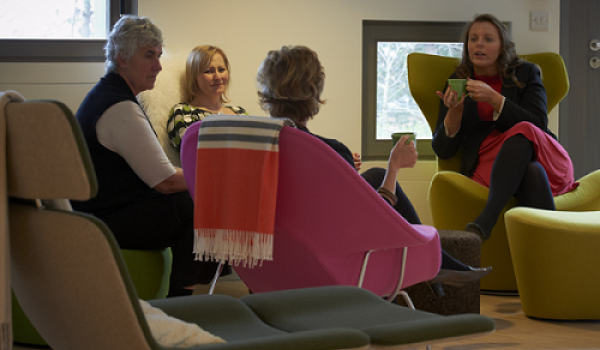 People sitting in comfortable chairs and talking at a cancer support centre