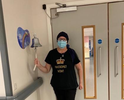 Dot after finishing treatment ringing a bell in the hospital and wearing a headscarf