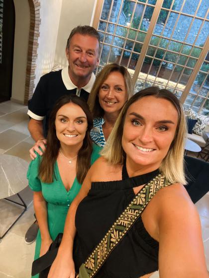 Treena and her family - her husband and two daughters - smiling on holiday before Treena was diagnosed with ovarian cancer