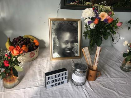A memorial table for Samantha with a photo of her, candles and flowers