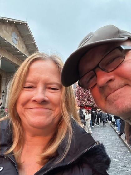 A photo of Judy and her partner both smiling to the camera taking a selfie