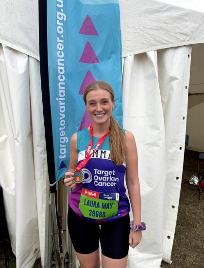 A photo of Laura smiling after finishing the Great North Run - she is wearing her medal and a Target Ovarian Cancer tshirt