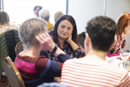 Women sat down at a table talking to each other during a Target Ovarian Cancer support event