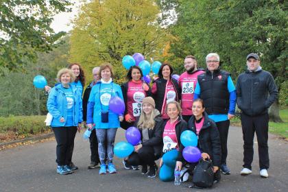A group of fundraisers at the Ovarian Cancer Walk|Run holding balloons and smiling at the camera.JPG