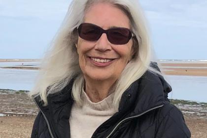 Mo at the beach wearing sunglasses smiling for a photo