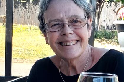 A photo of Helen sat at a restaurant smiling