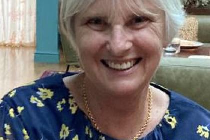 Liz Mitchell wearing a blue floral top smiling
