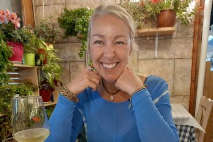 A photo of Karen smiling on holiday wearing a blue tshirt