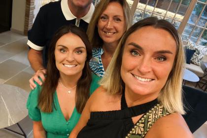 Treena and her family - her husband and two daughters - smiling on holiday before Treena was diagnosed with ovarian cancer