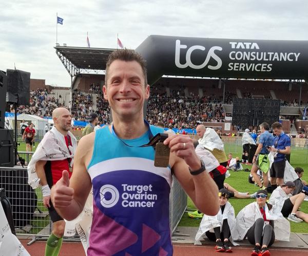A male supporter smiling at the Amsterdam Marathon 2025