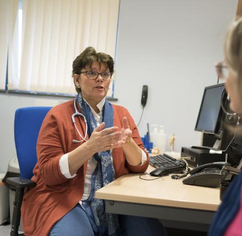A GP using hand gestures whilst talking to a woman with ovarian cancer