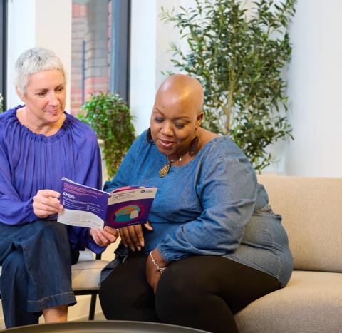 Two women reading a guide