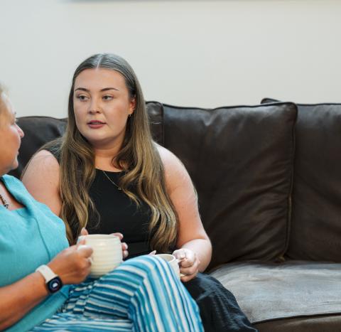 Jayne and her daughter talking on a sofa