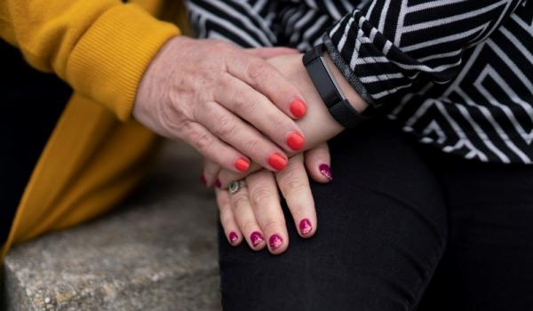 Close up of two people with painted nails holding hands