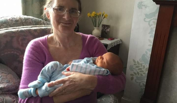 Gillian smiling holding her baby great nephew