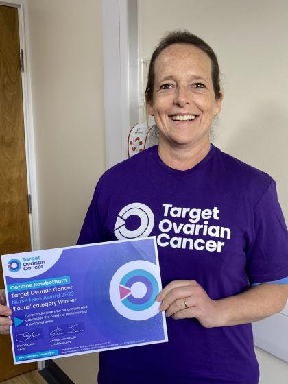 A photo of Corinne Rowbotham with her Nurse Hero Award certificate wearing a Target Ovarian Cancer tshirt