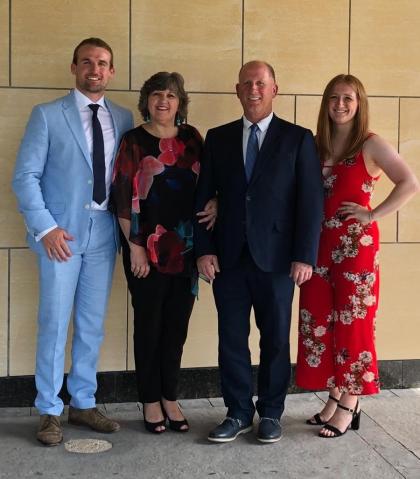Georgia and her family, her mum and dad and brother all standing together smiling