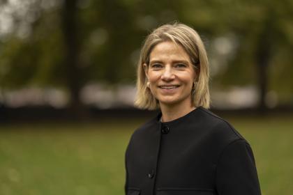 A headshot image of Catherine Hart, Target Ovarian Cancer CEO, wearing a black jacket and smiling at the camera