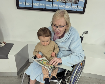 Sue in a wheelchair with her grandchild on her lap
