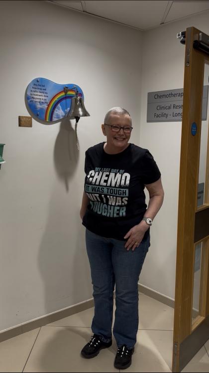 Lesley standing next to the treatment bell on the last day of her chemotherapy
