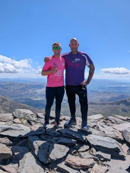 Adam standing on the top of Mount Snowdon with his friend. 
